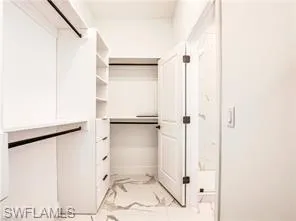 Spacious closet with light marble style finish flooring (Model Home) no shelving