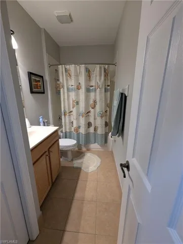 Full bathroom with vanity, toilet, tile patterned flooring, and visible vents