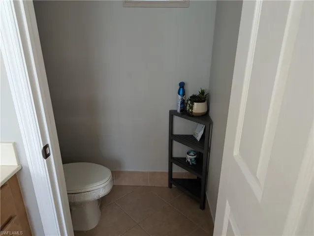Bathroom with vanity, toilet, and tile patterned flooring