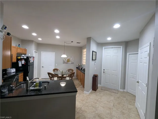 Kitchen with a peninsula, freestanding refrigerator, a sink, and recessed lighting