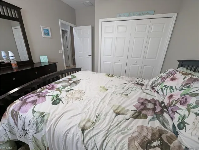 Bedroom featuring visible vents and a closet