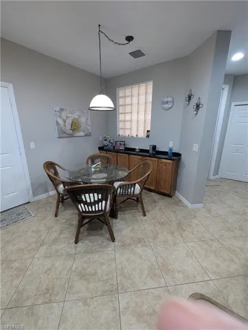 Dining area with baseboards, visible vents, and light tile patterned floors