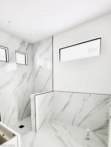 Bathroom featuring a marble finish shower