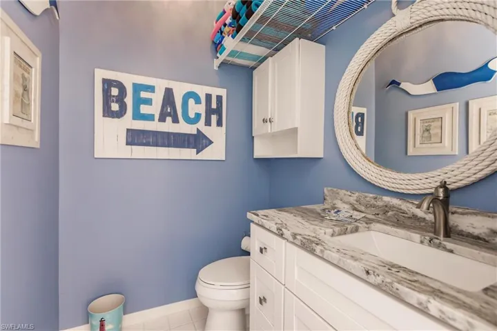 Bathroom featuring vanity with extensive cabinet space, toilet, and tile floors