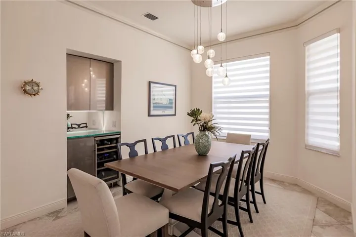 Tiled dining space featuring crown molding