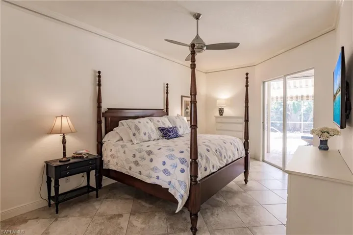 Tiled bedroom with ceiling fan, access to exterior, and crown molding