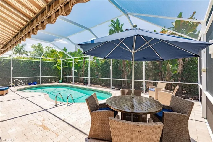 View of pool featuring a patio area and glass enclosure