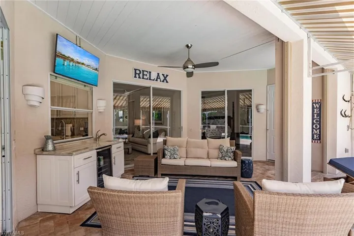View of terrace featuring outdoor lounge area, ceiling fan, and beverage cooler
