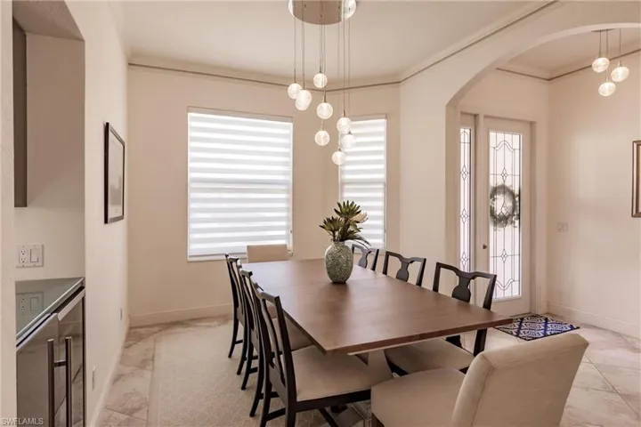 Dining area featuring ornamental molding, a healthy amount of sunlight, and light tile floors
