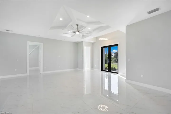 Unfurnished room featuring light marble finish floors, french doors, coffered ceiling, recessed lighting, and beam ceiling