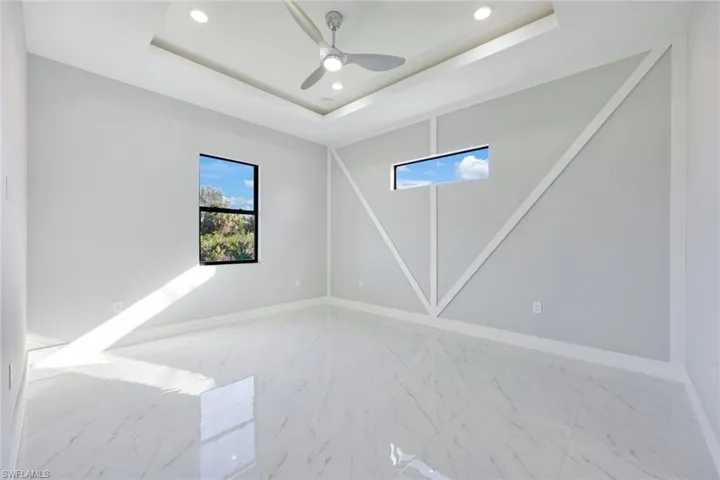 Spare room with recessed lighting, a tray ceiling, and ceiling fan