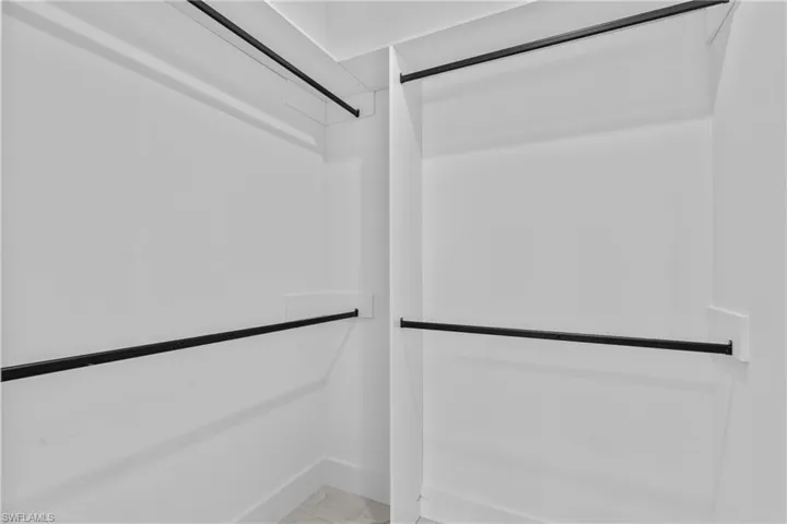 Walk in closet featuring marble finish floors
