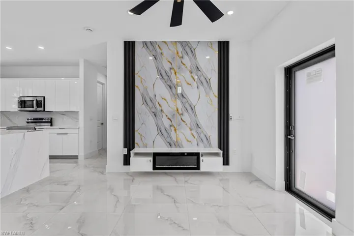 Unfurnished living room featuring light marble finish floors, recessed lighting, and ceiling fan