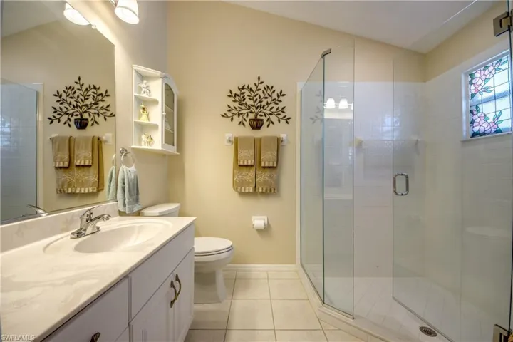 Master Bath with newer shower enclosure, newer commode, and re-faced vanity.
