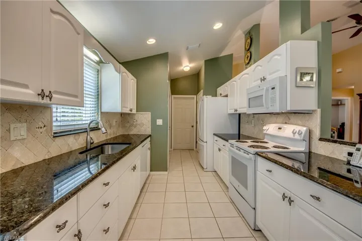 Refaced cabinets with gorgeous granite, tile backsplash and  large sink with waterfall spray faucet.