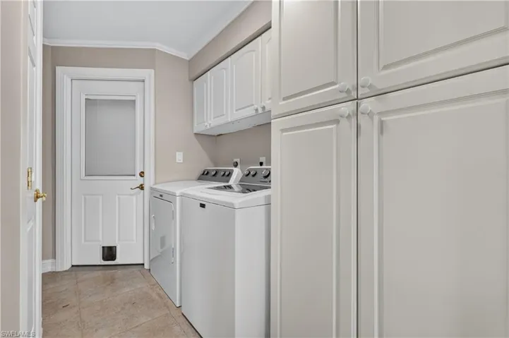 Laundry area featuring tile flooring, white cabinetry, a built-in washing machine, and a built-in dryer