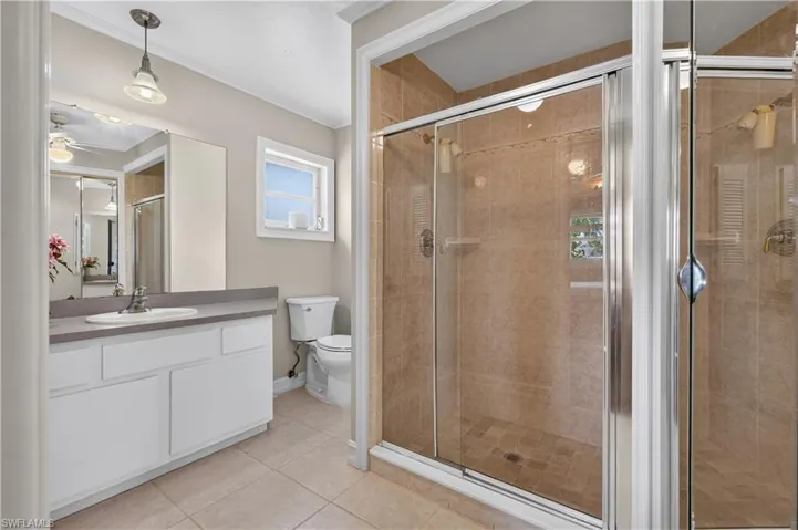 White vanity with a rectangular sink and gray countertop, complemented by a large wall mirror