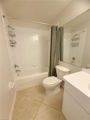 Bathroom with vanity, light tile patterned flooring, and shower / tub combo
