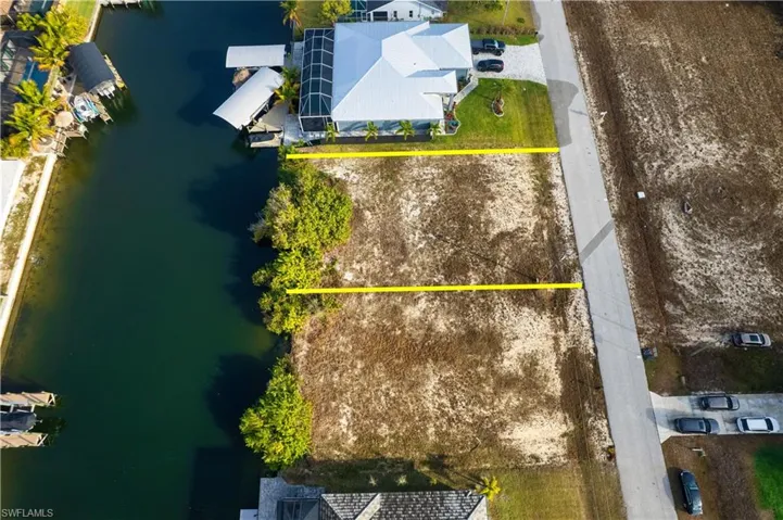Aerial overview of property's location featuring property boundaries highlighted and a nearby body of water