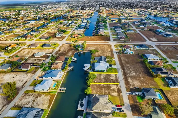 Aerial perspective of suburban area featuring a nearby body of water
