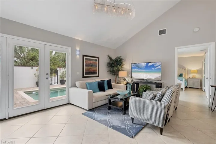 Living room with high vaulted ceiling, french doors, naturla light