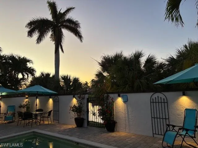 Pool at dusk featuring a patio area