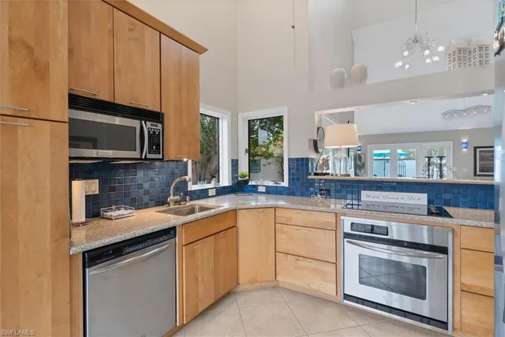 Kitchen featuring a high ceiling, stainless steel appliances