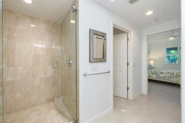 Ensuite bathroom featuring a shower stall, recessed lighting, a ceiling fan, and light tile patterned floors
