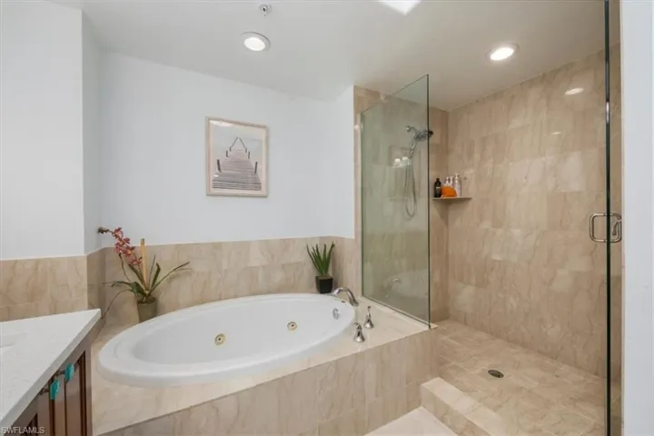 Full bathroom featuring a stall shower, vanity, a whirlpool tub, and recessed lighting