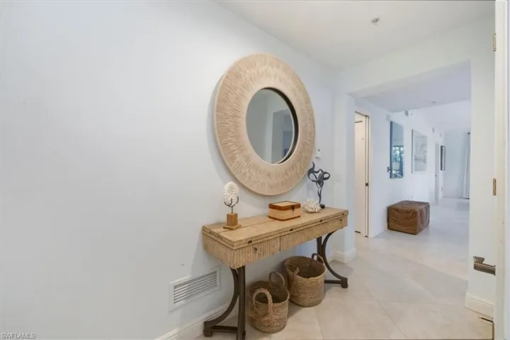 Hall featuring baseboards and light tile patterned floors