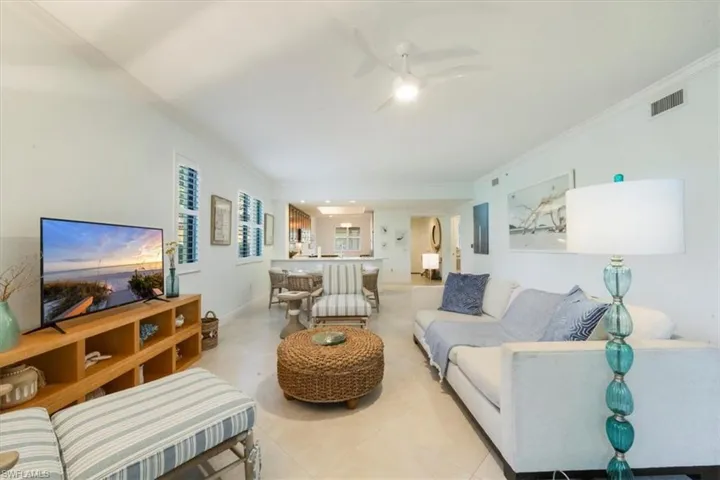 Living area featuring ornamental molding and a ceiling fan