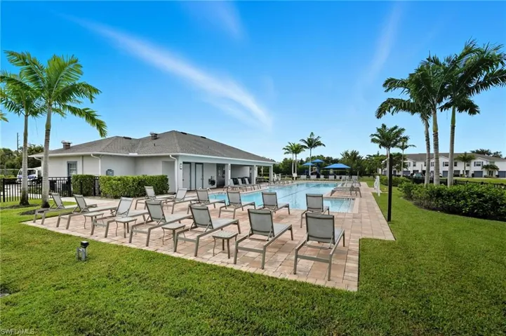 Community pool with a patio area and a yard