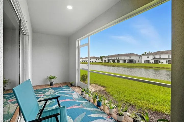 Sunroom with a water view and a residential view