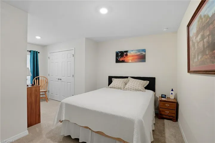 Bedroom with light colored carpet, recessed lighting, and a closet