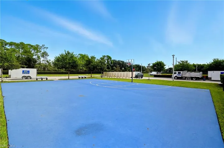 View of property's community featuring community basketball court and a yard
