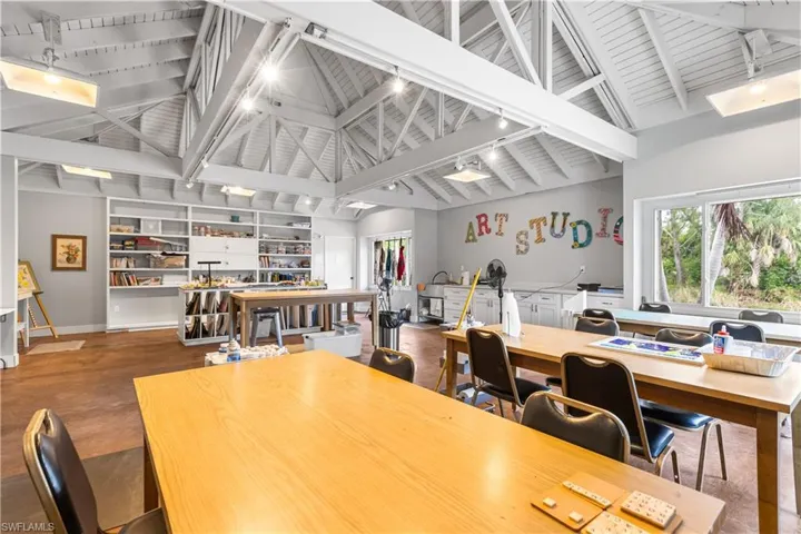Art Studio featuring beamed ceiling, high vaulted ceiling, hardwood / wood-style floors, and rail lighting
