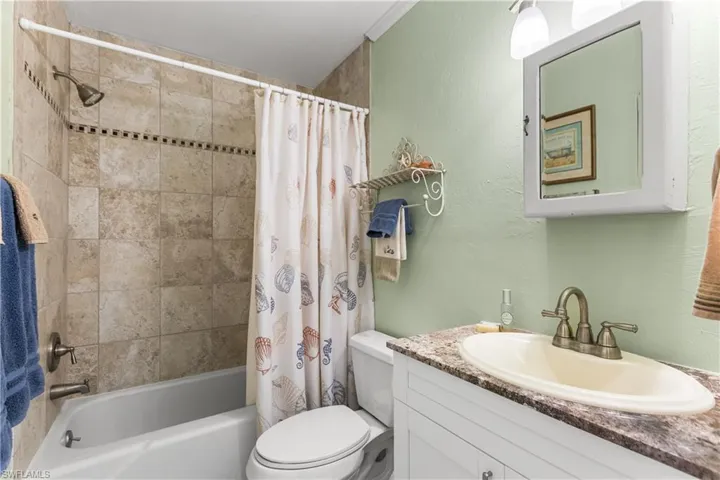 Full bathroom with vanity with cabinet space, shower / bath combo