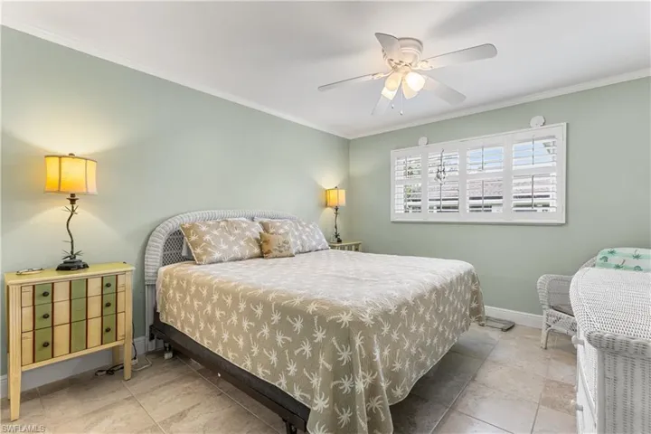 Primary Bedroom with tile flooring, ceiling fan, and crown molding