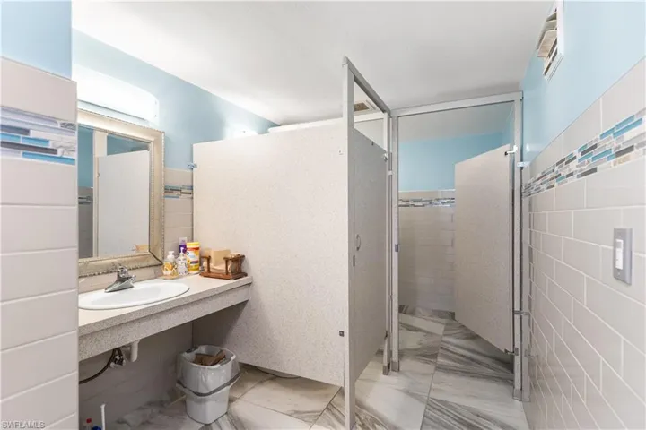 Bathroom featuring tile flooring, vanity, and tile walls