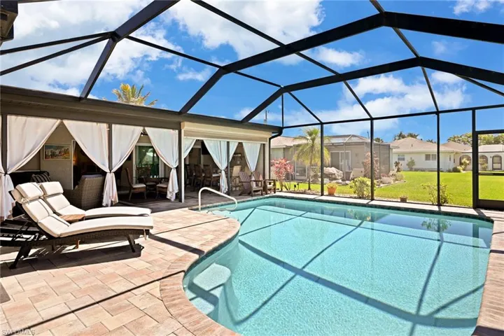 Outdoor pool with a lawn, a patio, screen enclosure, a residential view, and outdoor lounge area