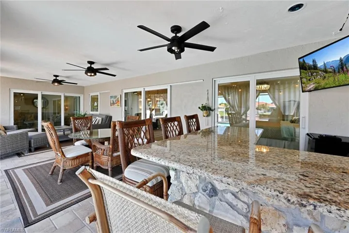 View of patio / terrace with an outdoor living space, outdoor dry bar, and a ceiling fan...BEDROCK BAR compliments of previous owner