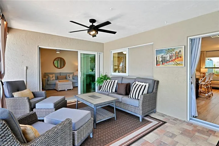 Patio Living area featuring a textured ceiling, light wood-style flooring, and remote control chandelier/fan