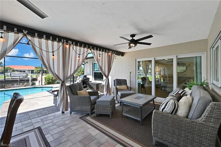 View of patio / terrace featuring an outdoor pool, screen enclosure, an outdoor hangout area, and curtains for privacy or added shade