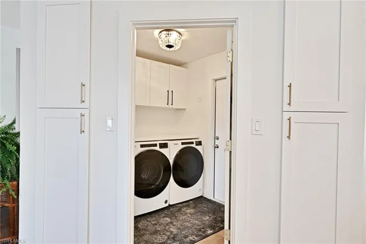 Laundry area with cabinet space and independent washer and dryer and door to access the oversized garage and work space