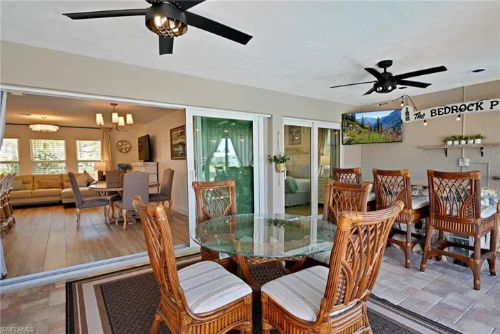 Dining space on the patio featuring stone finish floor, remote control fans/lights