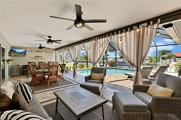 View of patio / terrace featuring an outdoor pool, an outdoor hangout area, a lanai, and Bedrock Bar built by previous owner from stone with granite top