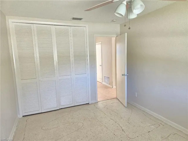 Unfurnished bedroom featuring a ceiling fan and a closet