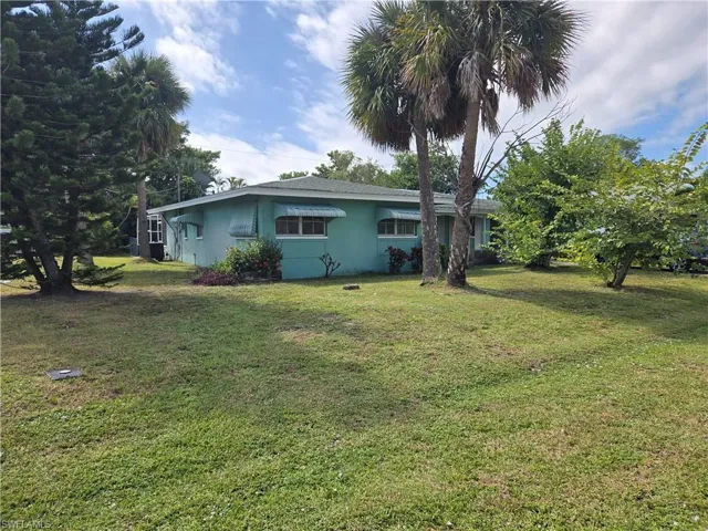 View of front of property featuring stucco siding and a front yard
