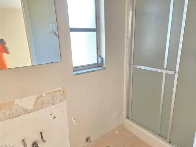 Bathroom featuring a shower stall and tile patterned flooring