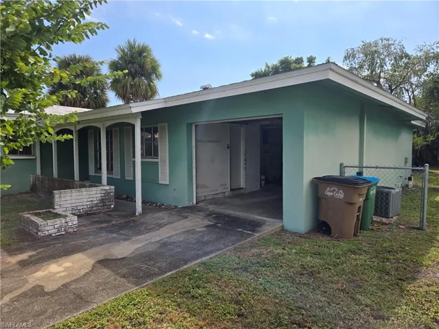 View of side of property with concrete driveway and a garage